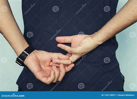 A Man In Struggling To Remove Wedding Ring From His Finger Holding