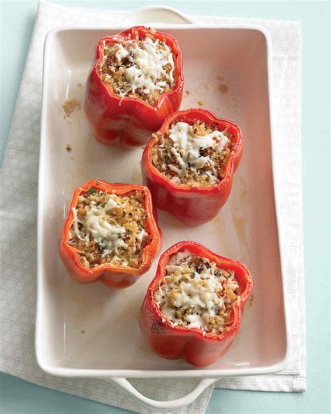 four stuffed red peppers on a plate with cheese and seasoning in the middle ready to be eaten