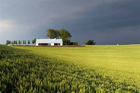 A Green Field With A House In The Distance