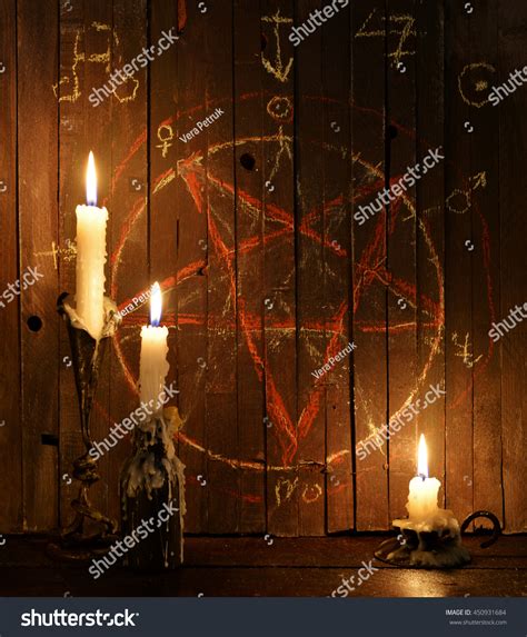 Three Burning Candles Against The Background Of Wooden Planks With