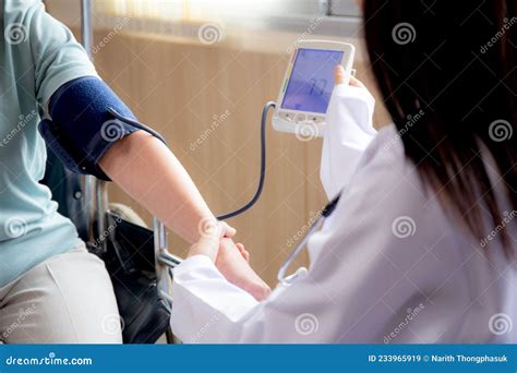 Doctor Woman In Uniform Measuring Blood Pressure With Patient Elderly