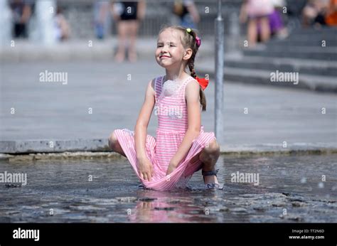 Strong Heat In The City Girl Playing With Fountain Water Jets At The