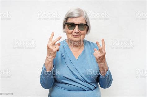 Cool Grandmother In Sunglasses Showing Victory Gesture With Two