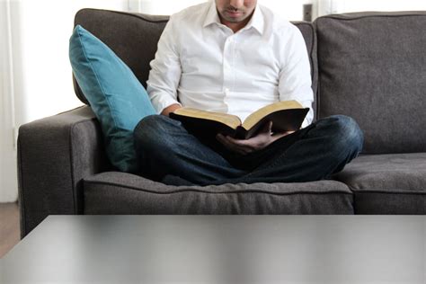 A sofa which allows the user to store books as an integral part of the sofa #book #books #living_room #reading #reading_sofa #salon #seating #sitting #sofa. Free Stock Photo of Man on Couch Reading Bible