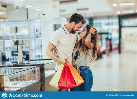 Couple Having Fun In Shopping Mall While Doing Shopping Together