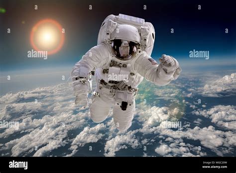 Astronaut In Outer Space Against The Backdrop Of The Planet Earth