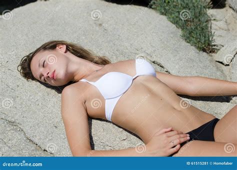 Woman Is Lying Down And Sunbathing On Solid Rocks Stock Photo Image