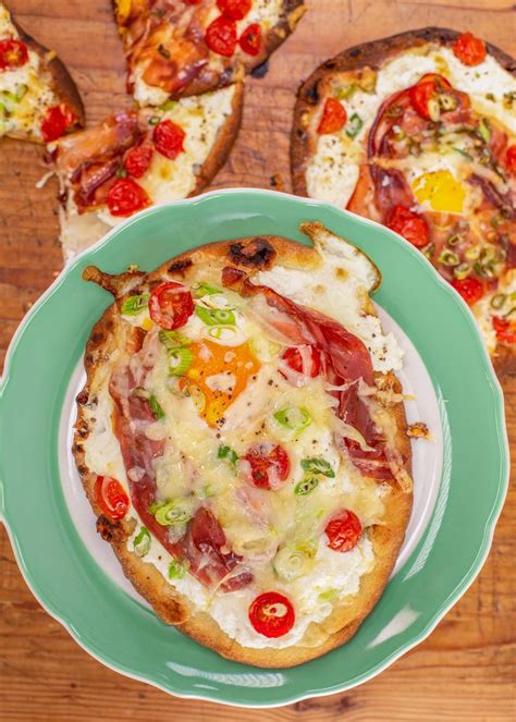 Two Pizzas With Different Toppings Sit On A Plate Next To Some Bread Slices