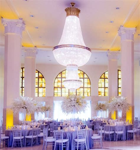 An Elegant Ballroom With Chandelier And White Flowers