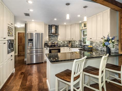 Wood is a common material used in construction, especially in the kitchen. Cream Colored Cabinetry, wood floors, dark granite ...