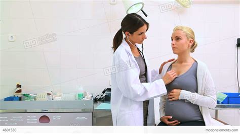 Female Doctor Auscultating A Pregnant Woman On An Stock Video Footage