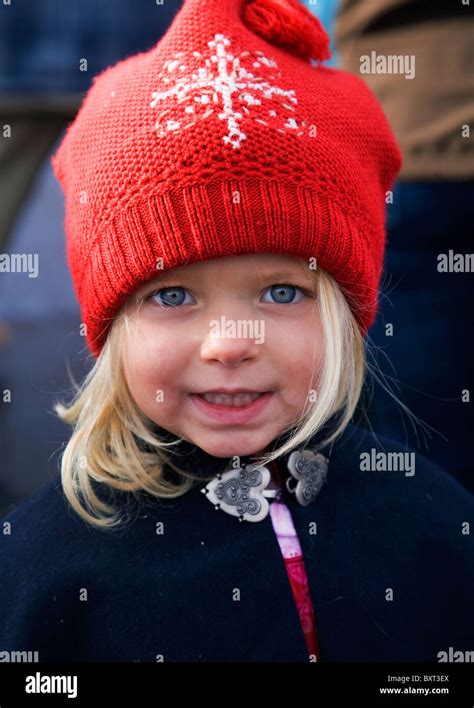A Pretty Three Year Old Blonde Girl Dressed In A Red Wool Hat Stock