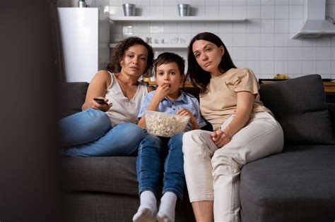 coppia lesbica con il figlio che guarda un film foto gratis