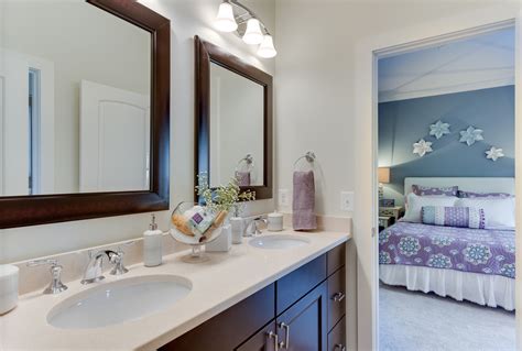 Jack and jill bathroom features frameless mirrors flanking steel framed window dressed in white roman shade over wood double washstand topped with thick white quartz countertop and rectangular sinks accented with modern faucets over octagon tiled floor from artobrick tiles. Jack & Jill Bathroom Ideas | Home decor, Remodel, Framed ...
