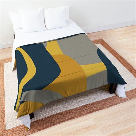 The Bed Is Made Up And Has Yellow Blue Gray And White Designs On It