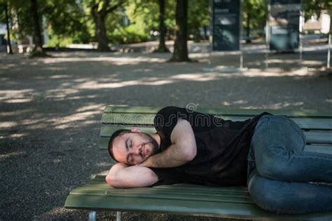 Young Handsome Bearded Man Is Sleeping On A Park Bench Stock Image