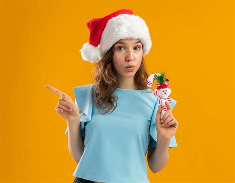 Free Photo Young Woman In Blue Top And Santa Hat Holding Christmas
