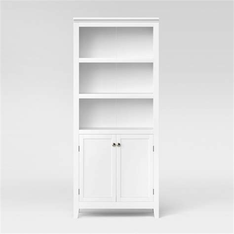 A White Bookcase With Two Doors And One Door Open On The Bottom Shelf