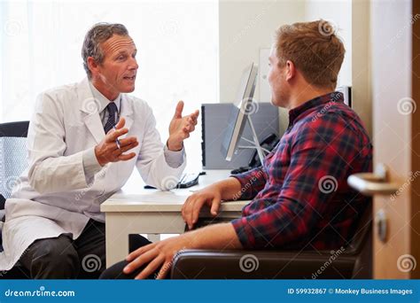Patient Having Consultation With Male Doctor In Office Stock Image