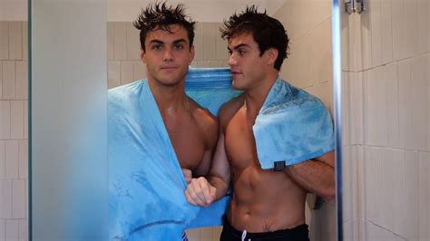 Two Men Standing In The Shower Wrapped In Blue Towels