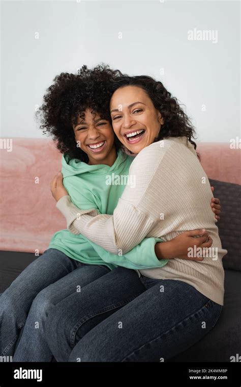 Excited African American Mother And Daughter Hugging While Sitting On