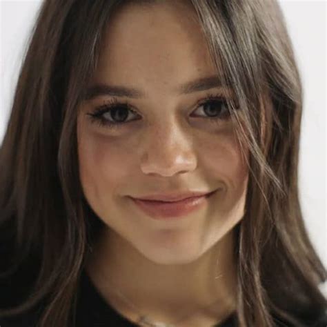 A Close Up Of A Person Wearing A Black Shirt And Smiling At The Camera