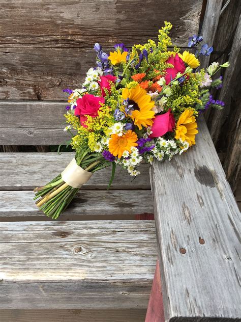 wildflower vibrant country wedding bouquet with depth and texture roses sunflowers delp