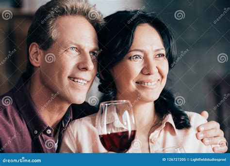 Happy Multiethnic Couple Drinking Red Wine And Looking Stock Image