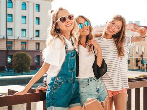 トレンディな夏服の3人の若い美しい笑顔流行に敏感な女の子の肖像画。セクシーな屈託のない女性が路上でポーズします。 無料の写真