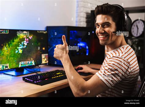 Portrait Of Joyful Gamer Guy In Headphones Playing Video Games On