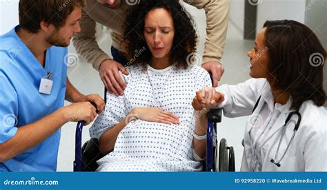 Doctors And Man Comforting Pregnant Woman In Corridor Stock Footage