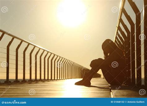 Sad Teenager Girl Depressed Sitting In A Bridge At Sunset Stock Photo