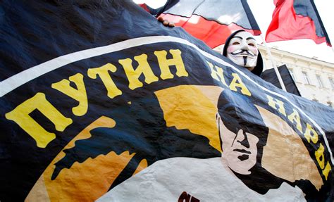 A Russian Anarchist Wearing A Guy Fawkes Mask Holds A Placard During A