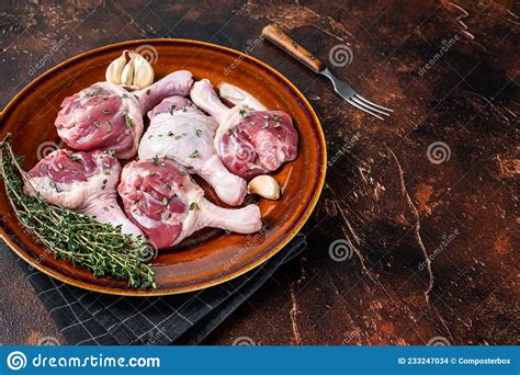 Raw Poultry Meat Duck Legs Drumsticks On A Rustic Plate With Herbs Dark Background Top View