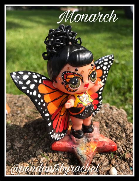 A Small Doll With Black Hair And Butterfly Wings