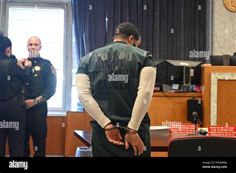 Cesar Santana in court wearing a jailhouse uniform and handcuffs. Cesar