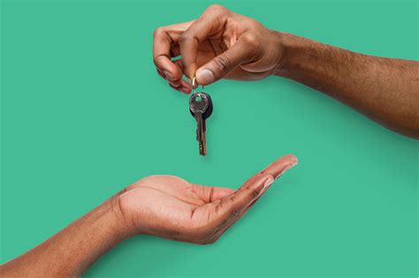 Black Man Handing Key Over To Person Hand Stock Photo Download Image