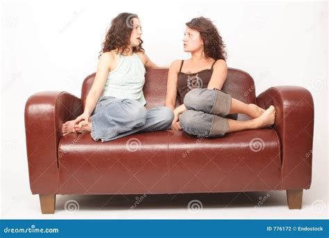Mujeres Jovenes Que Se Sientan En El Sofá Y Hablar Foto De Archivo Imagen De Tranquilizador