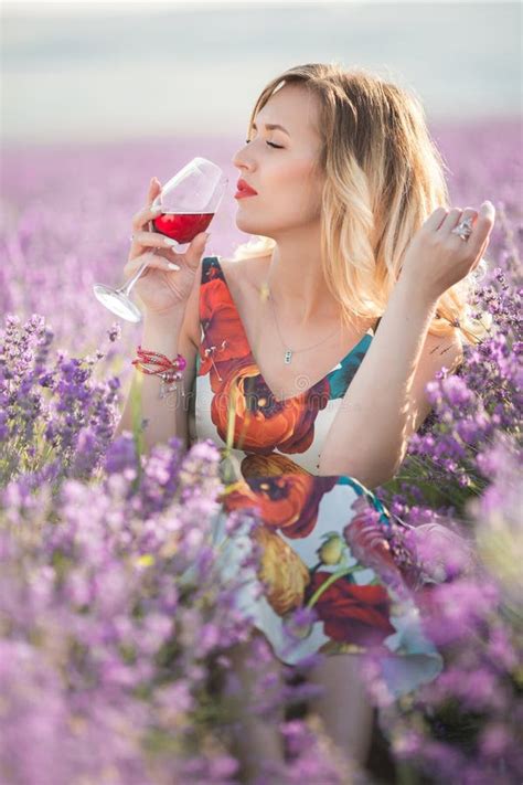 Portrait Of Beautiful Woman Is Drinking Red Wine In Lavender Field