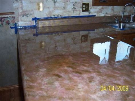 The product recommended for a high gloss, thick, durable sealer (like bar tops) is called envirotex, it comes in a mix, and you can see numerous pics of countertops/sinks (wood, granite, etc) online, along with instructions from others on the best way to cover curves, lips and back splashes. 2 Coats of Envirotex | ThriftyFun