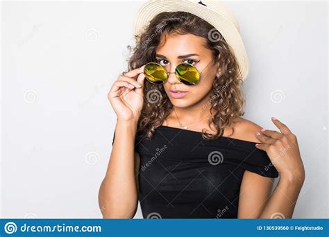 Cheerful Curly Mulatto Girl In Sunglasses And Straw Hat Laughing On White Background Portrait