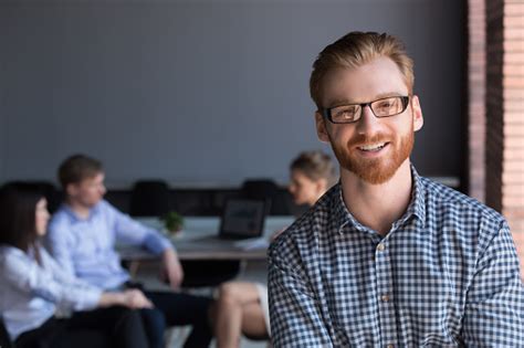 Portrait Of Smiling Male Employee Posing During Company Briefing Stock