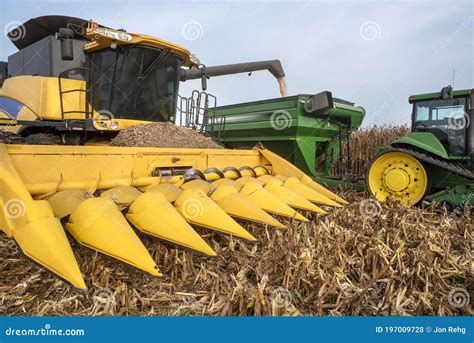 Harvester Combine Dumping Corn Into Grain Cart On Back Of Tractor In