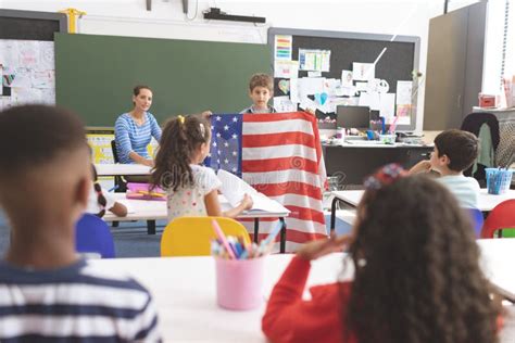 Schoolboy Holding An American Flag In Classroom Stock Photo Image Of