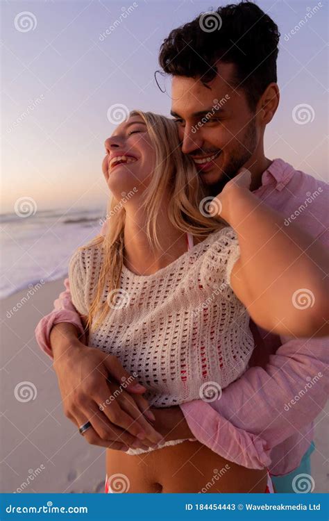 caucasian couple enjoying time at the beach during the sunset stock image image of enjoying