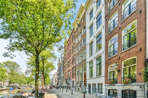 A City Street With Tall Brick Buildings And Green Trees Editorial Image
