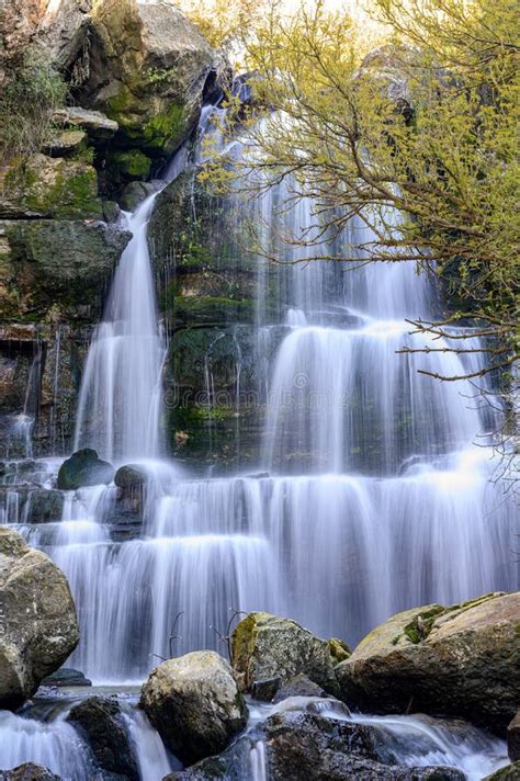 A Beautiful Waterfall In The Woods Between Big Rocks Stock Photo