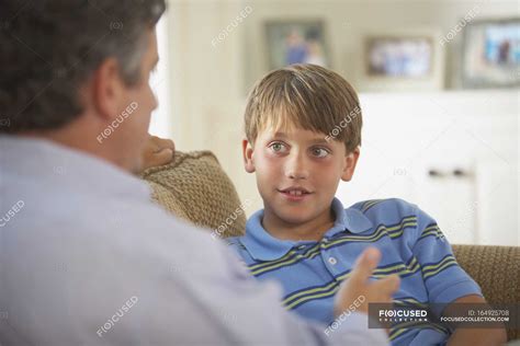 Отец и сын разговаривают дома ребенок Зрелый взрослый Stock Photo