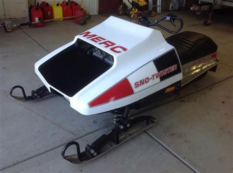 A White And Red Snowmobile Parked In A Garage