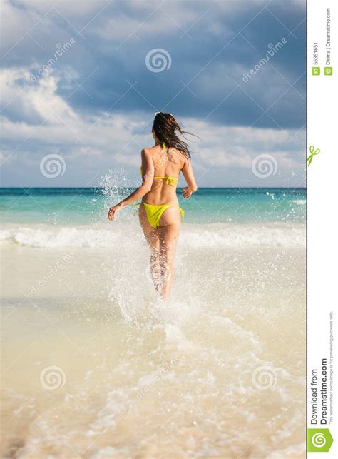 Woman On Caribbean Vacation Running To The Sea Splashing Stock Image